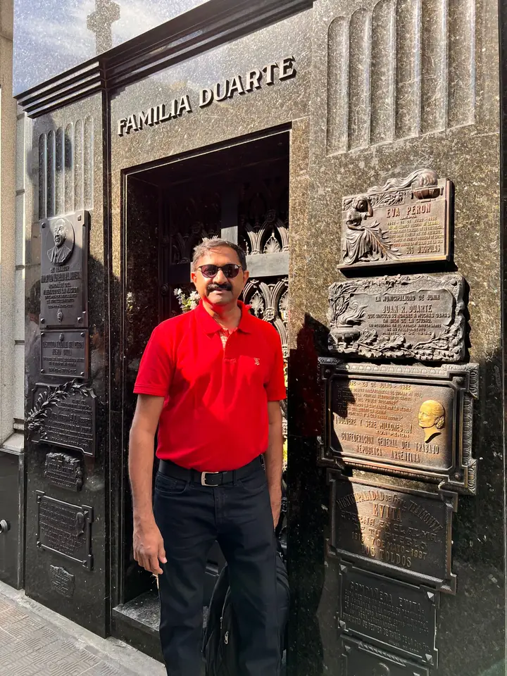 A visitor stands before the black granite Familia Duarte vault, La Recoleta Cemetery
